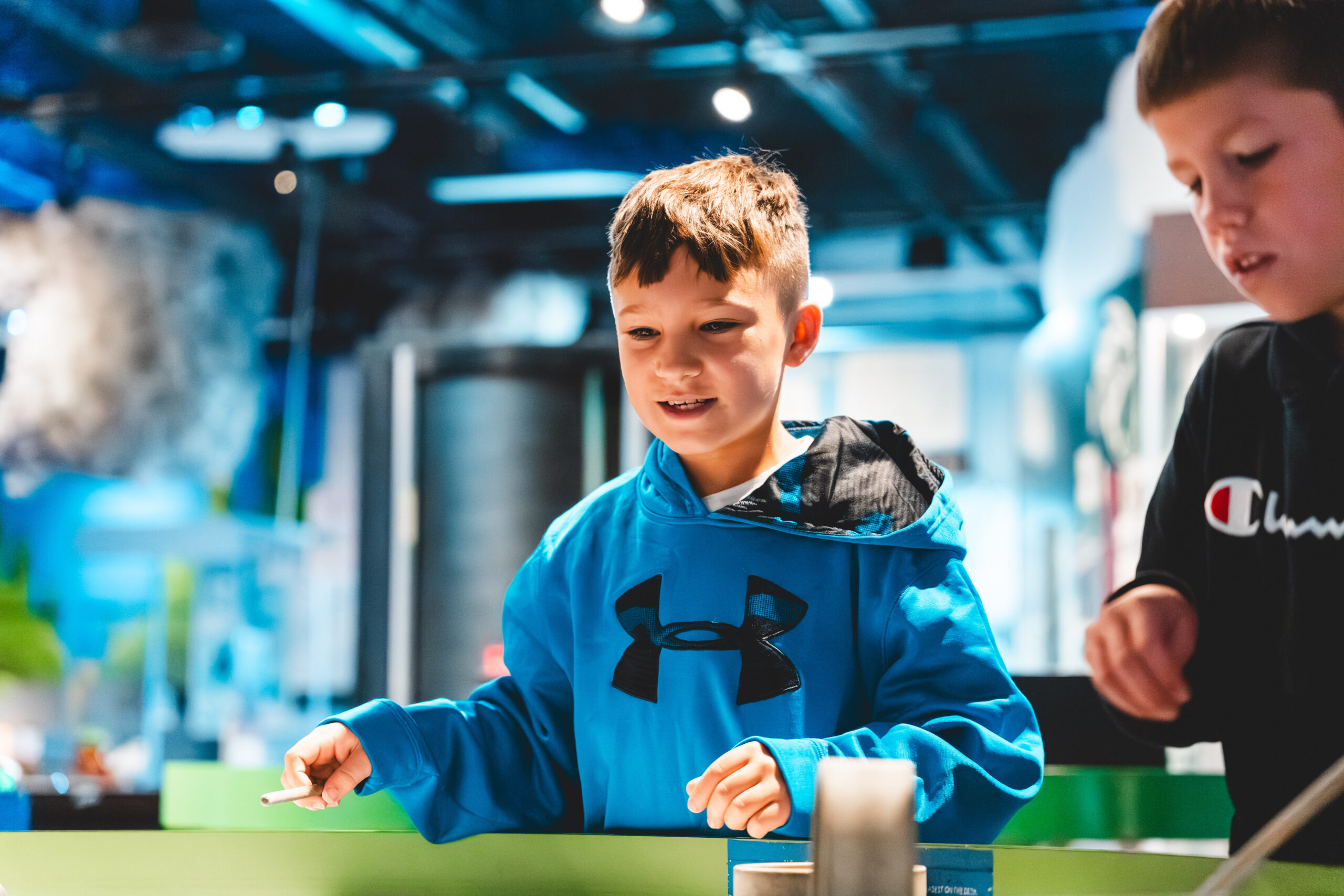 2 little boys playing in an exhibit in edgerton center